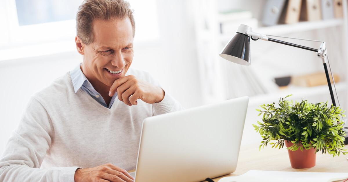 man-smiling-at-computer-screen