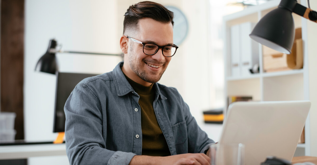 man-smiling-at-laptop-screen