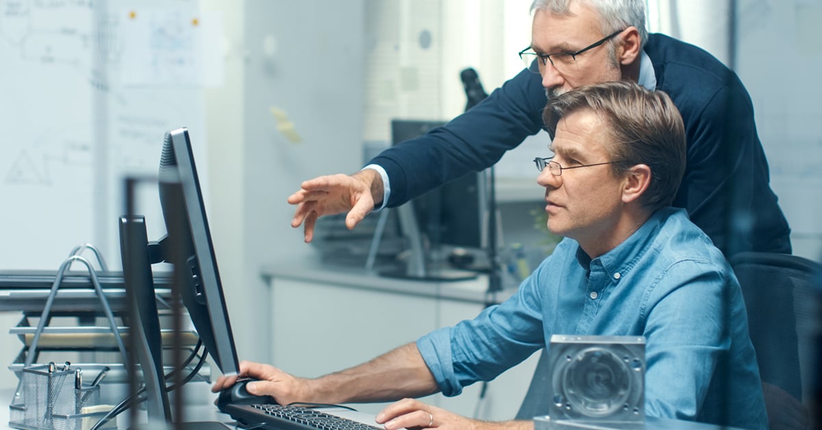 two men working at one computer