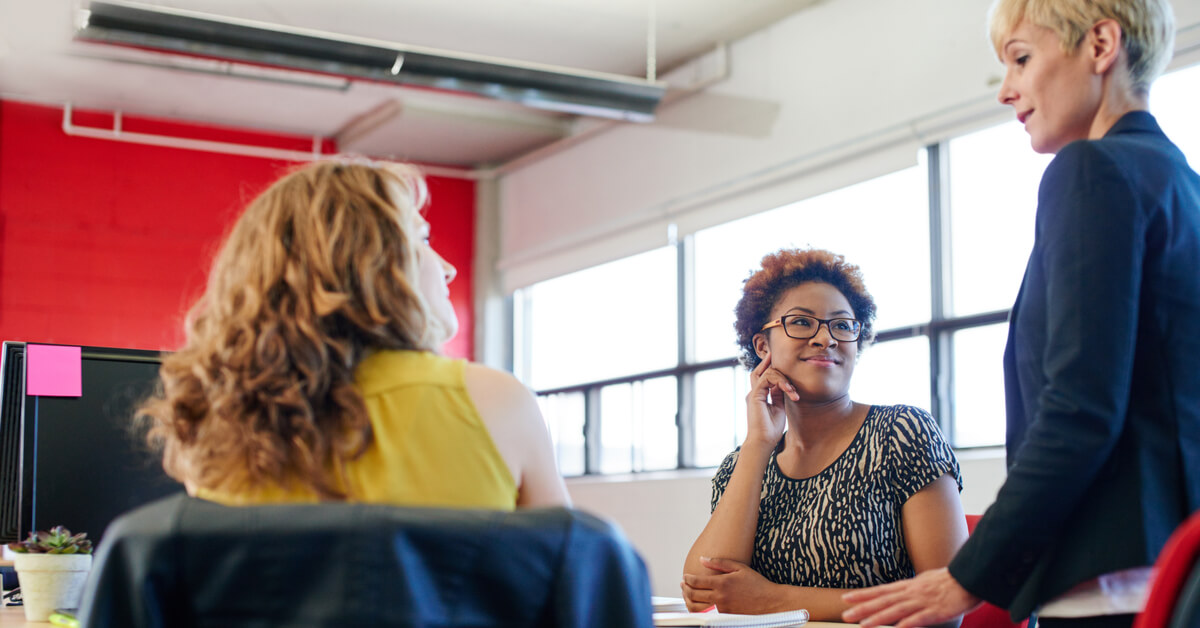 three-colleagues-in-conversation-around-table