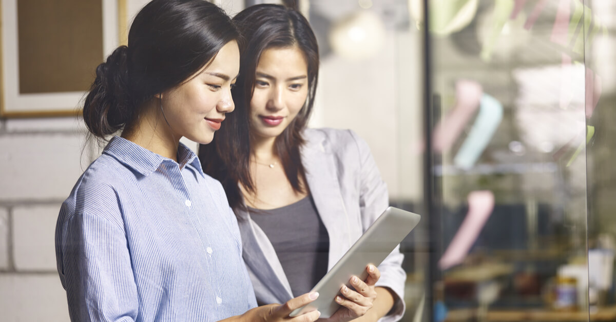 two-coworkers-looking-at-tablet-screen